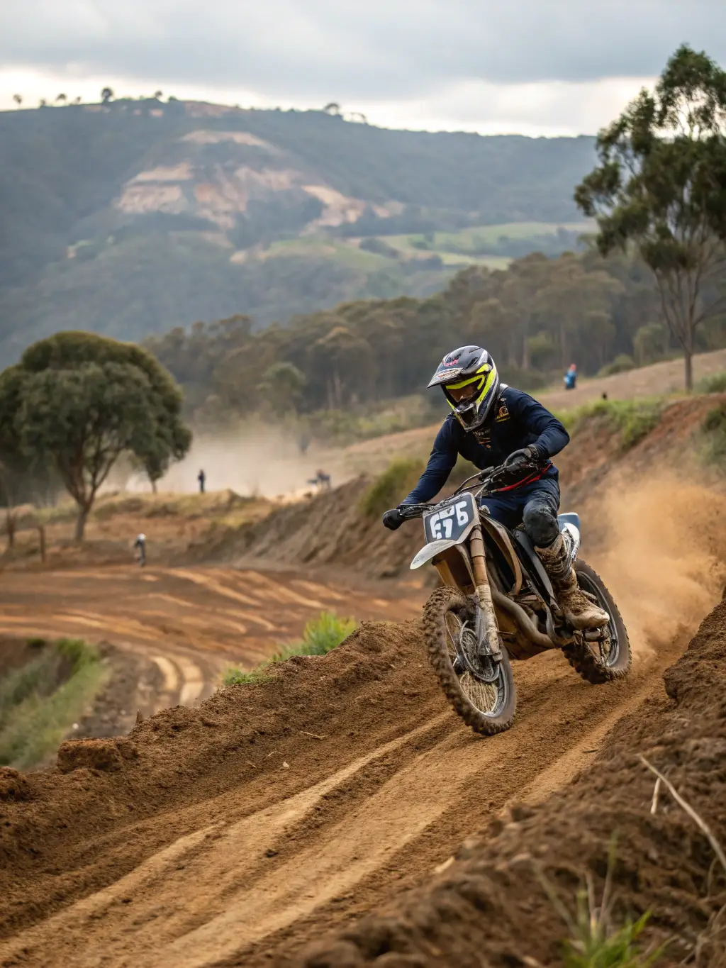 A young rider confidently navigating a motocross track on a dirt bike, showcasing skill and control, with the LEYNHAC-MOTO-QUAD logo subtly visible in the background.